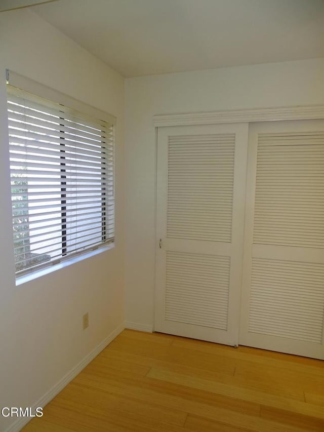 unfurnished bedroom with light hardwood / wood-style floors and a closet