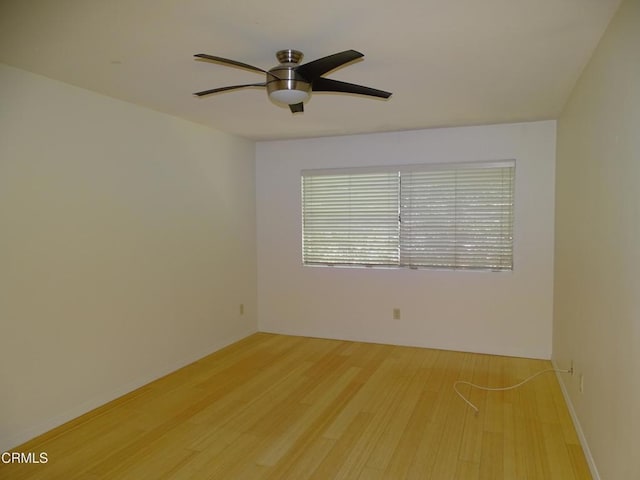 spare room with ceiling fan and light wood-type flooring