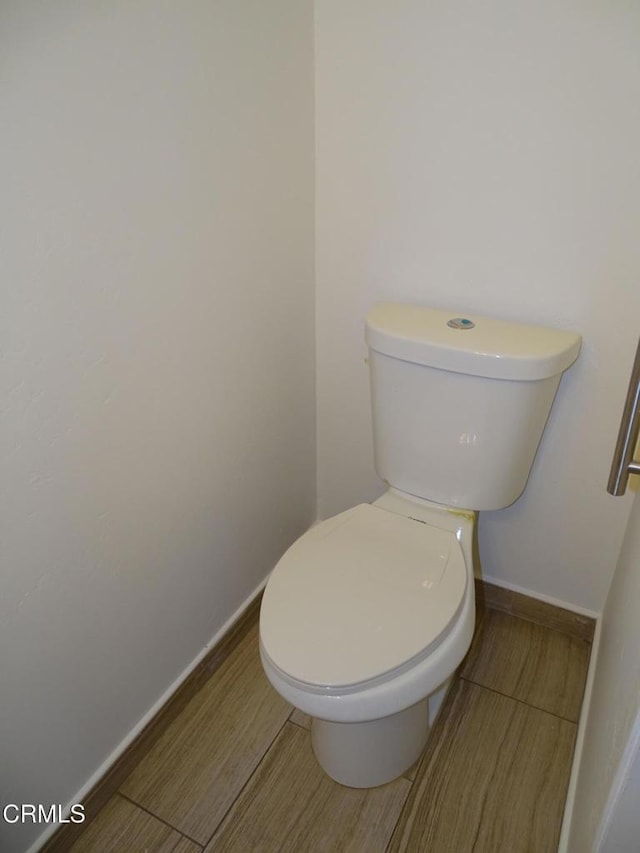 bathroom with hardwood / wood-style floors and toilet