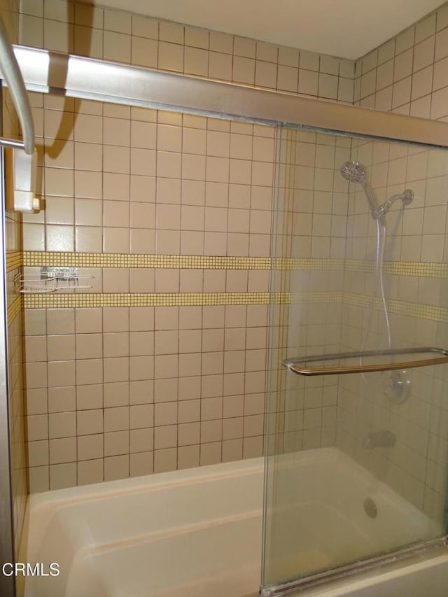 bathroom with bath / shower combo with glass door