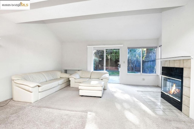 unfurnished living room with a fireplace, vaulted ceiling, and light colored carpet