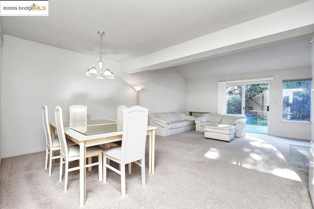 dining space featuring an inviting chandelier, beamed ceiling, and carpet