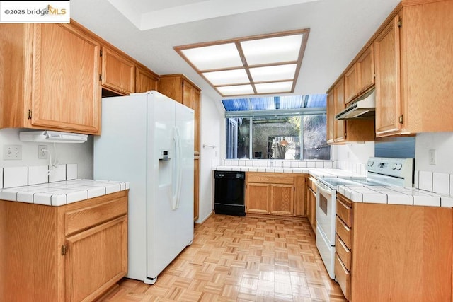 kitchen with white appliances, tile counters, and light parquet flooring