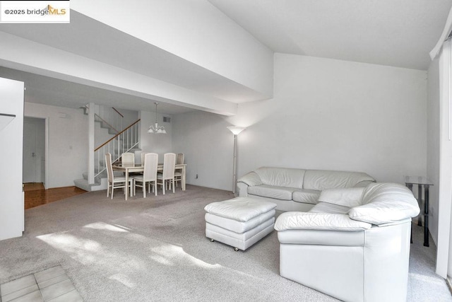 carpeted living room featuring an inviting chandelier