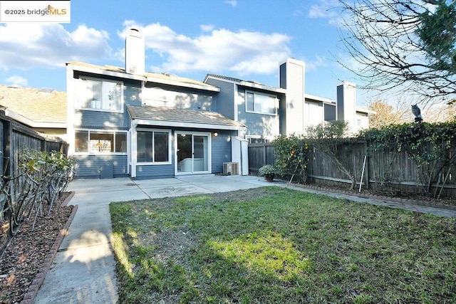 rear view of property with a yard, a patio area, and central air condition unit