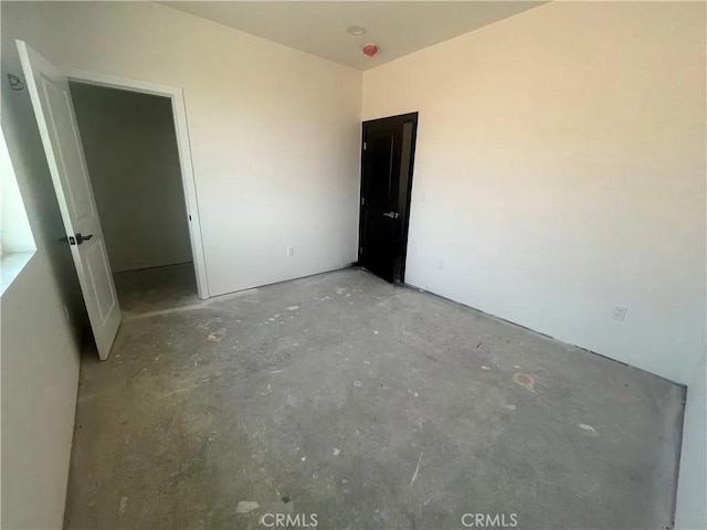 unfurnished bedroom with concrete flooring