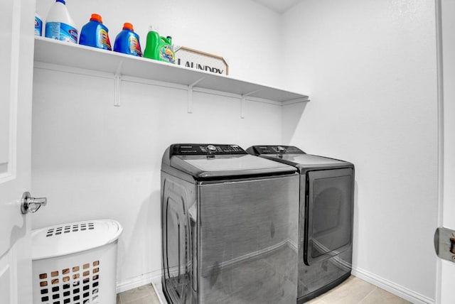 clothes washing area featuring washing machine and dryer and light tile patterned floors