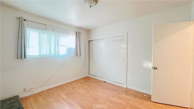 unfurnished bedroom featuring light hardwood / wood-style floors and a closet