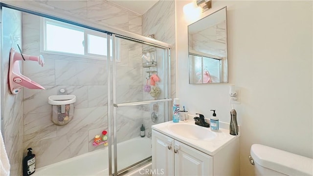 full bathroom featuring enclosed tub / shower combo, vanity, and toilet