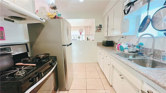 kitchen featuring white cabinetry, gas stove, sink, and light tile patterned floors