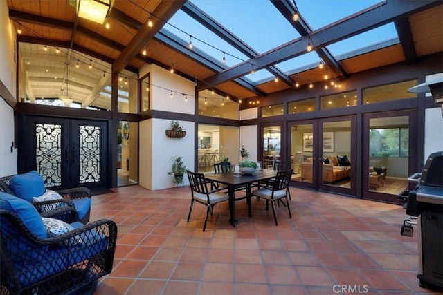 sunroom / solarium featuring french doors, vaulted ceiling with skylight, rail lighting, and wooden ceiling