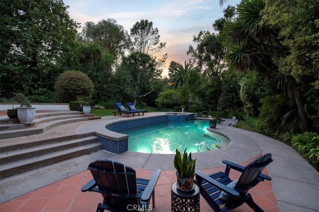 pool at dusk with a patio