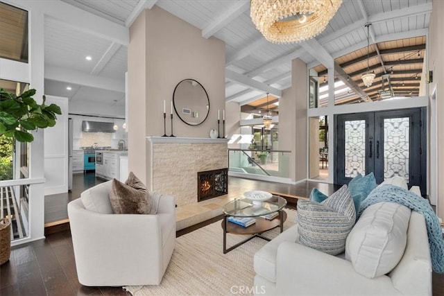 living room with vaulted ceiling with beams, a notable chandelier, wood ceiling, dark wood-type flooring, and french doors