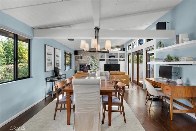 dining space with a notable chandelier, a fireplace, lofted ceiling with beams, and dark hardwood / wood-style floors