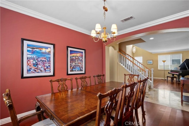 dining space with ornamental molding and a chandelier