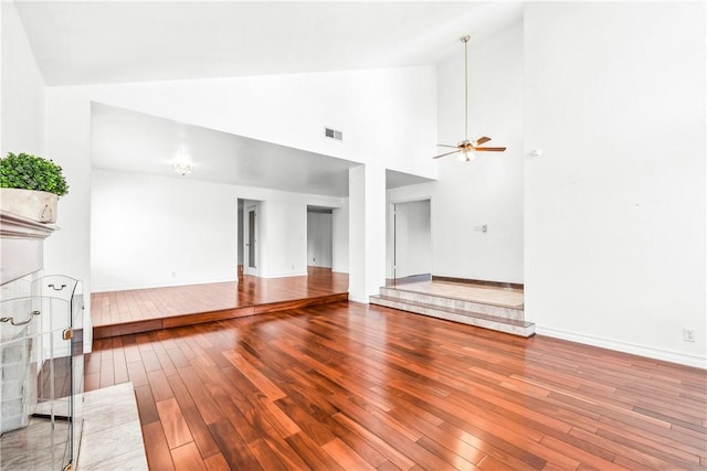 unfurnished living room with hardwood / wood-style flooring, high vaulted ceiling, and ceiling fan