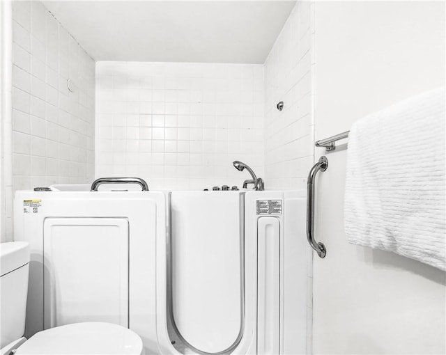 bathroom with washer / dryer and toilet