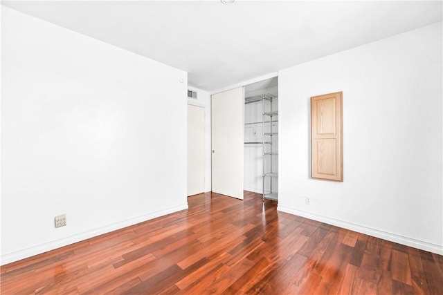 unfurnished room with dark hardwood / wood-style flooring