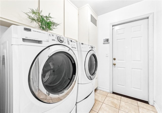 clothes washing area featuring washer and clothes dryer and light tile patterned flooring