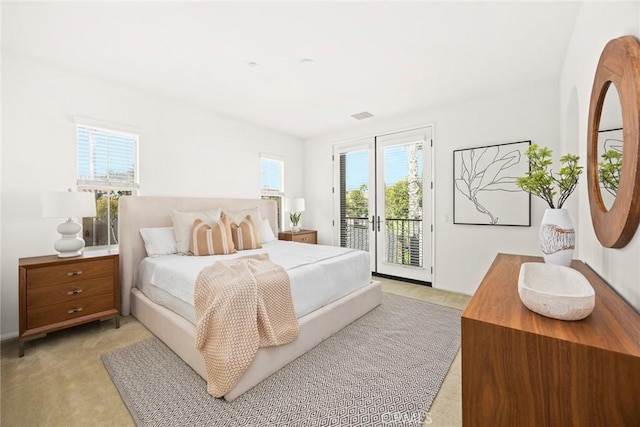 bedroom featuring light carpet and access to exterior