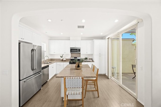 kitchen featuring a kitchen island, appliances with stainless steel finishes, sink, and white cabinets