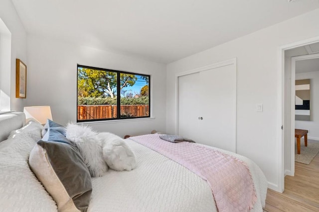 bedroom with light wood-type flooring and a closet