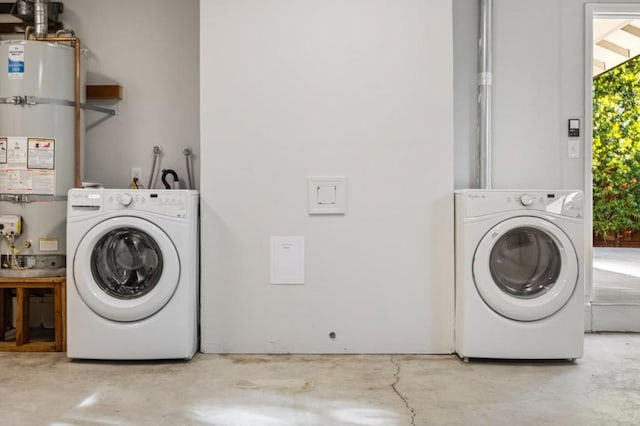 laundry area with washing machine and clothes dryer and strapped water heater