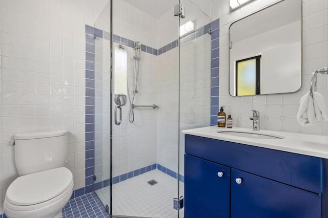 bathroom featuring tile walls, tile patterned flooring, vanity, toilet, and walk in shower