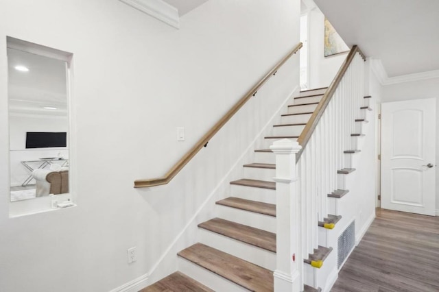 stairway featuring crown molding and hardwood / wood-style floors