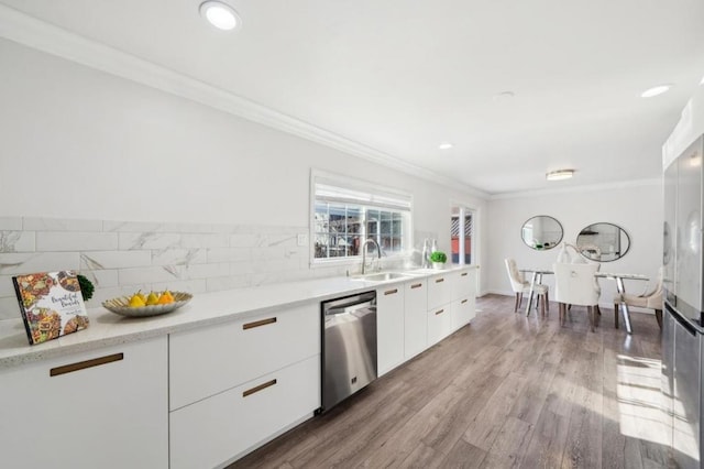 kitchen with sink, crown molding, stainless steel dishwasher, hardwood / wood-style flooring, and white cabinets