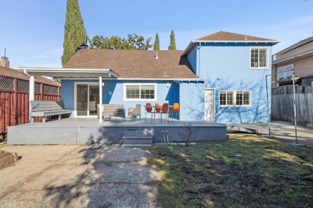 back of property featuring a wooden deck, a yard, and a patio area