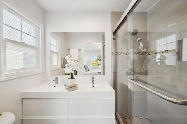 bathroom featuring vanity, a shower with shower door, and toilet