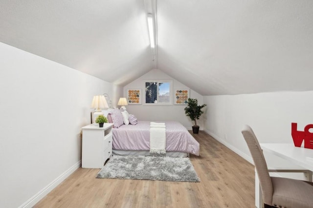 bedroom with light hardwood / wood-style floors and vaulted ceiling