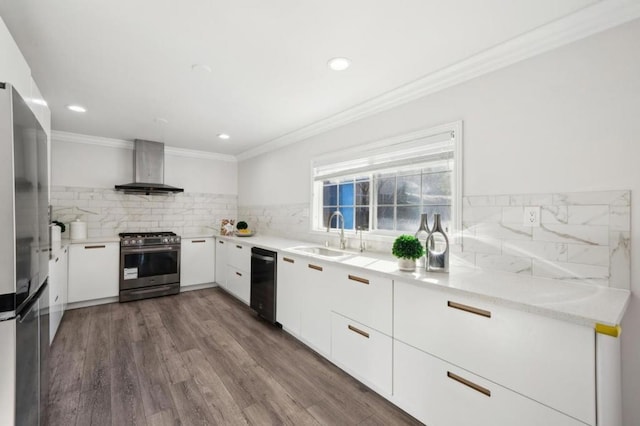 kitchen with sink, appliances with stainless steel finishes, wall chimney range hood, decorative backsplash, and white cabinets