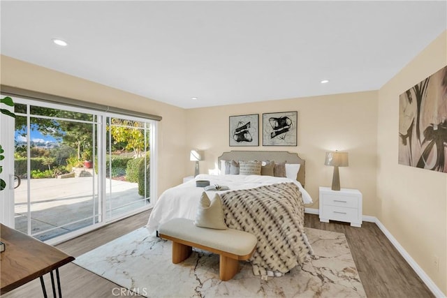 bedroom with access to exterior and hardwood / wood-style floors