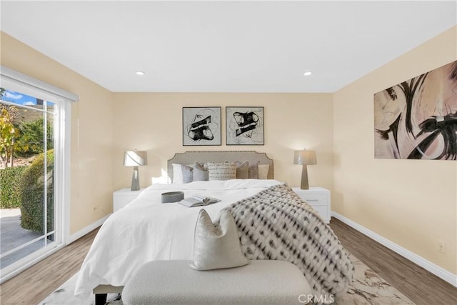 bedroom featuring wood-type flooring and access to outside