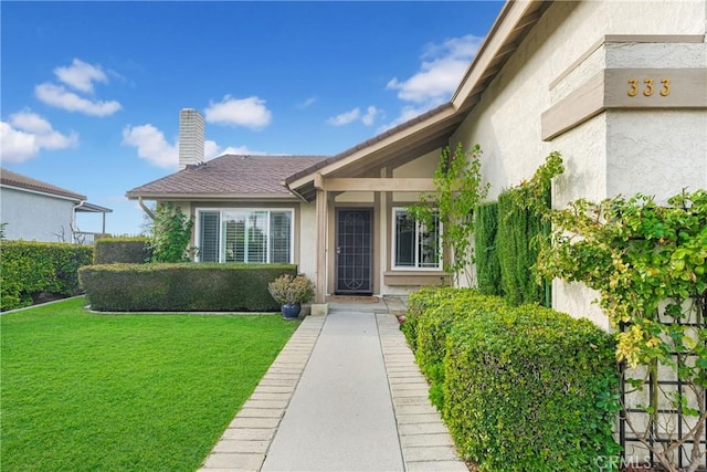 doorway to property with a lawn