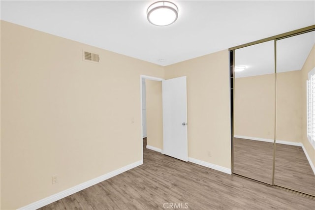 unfurnished bedroom featuring a closet and light wood-type flooring