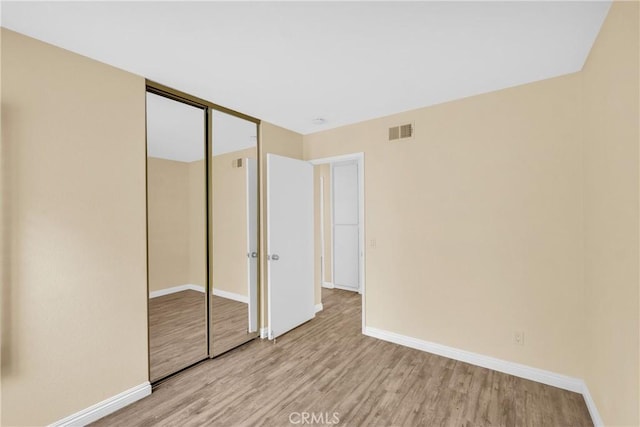 unfurnished bedroom featuring a closet and light wood-type flooring