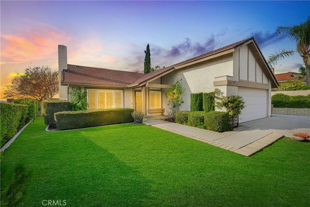 ranch-style home with a garage and a lawn