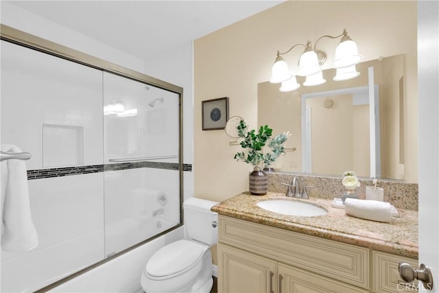 full bathroom with vanity, combined bath / shower with glass door, and toilet