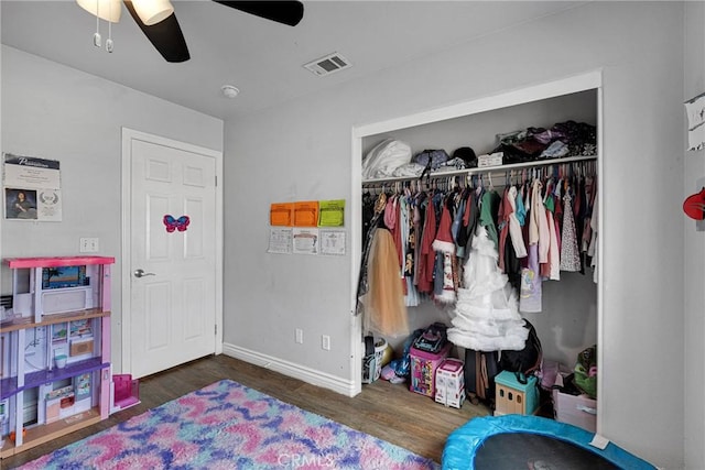 bedroom featuring dark wood-type flooring, a closet, and ceiling fan