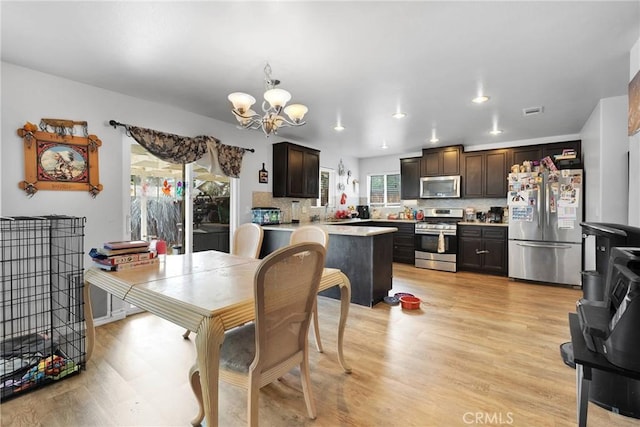 dining space with a chandelier and light hardwood / wood-style floors