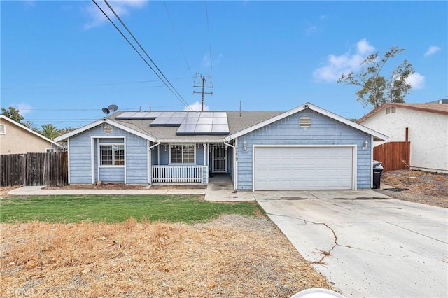 ranch-style home featuring a garage, covered porch, a front yard, and solar panels