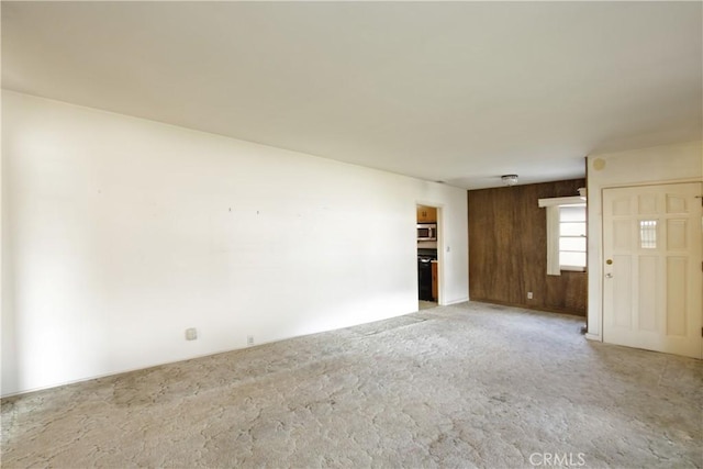 interior space with light colored carpet and wood walls