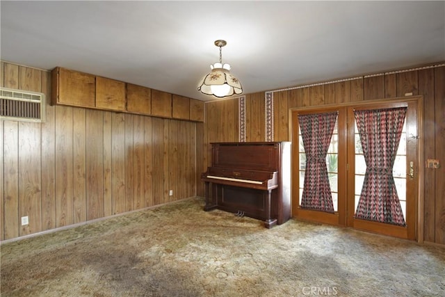 unfurnished living room with light carpet, a wall mounted AC, and wood walls