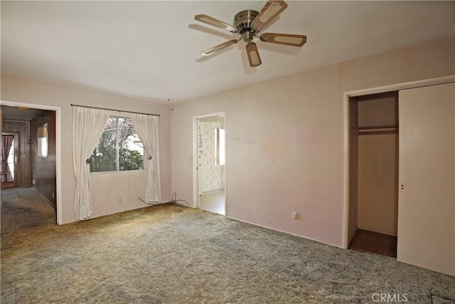 unfurnished bedroom with ensuite bathroom, carpet, ceiling fan, and a closet