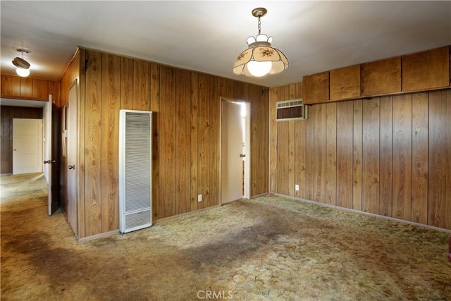 carpeted spare room featuring a wall mounted air conditioner and wooden walls