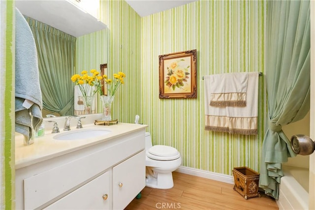 bathroom featuring vanity, wood-type flooring, and toilet