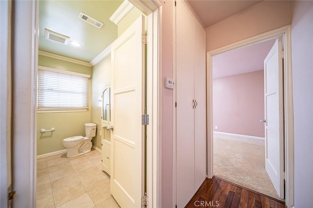 bathroom with crown molding, hardwood / wood-style floors, and toilet